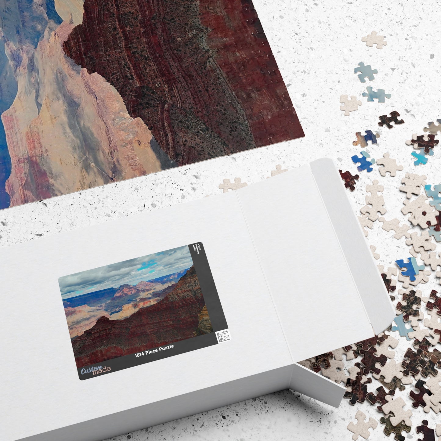 Jigsaw puzzle with completed pieces and a box featuring a scenic design.