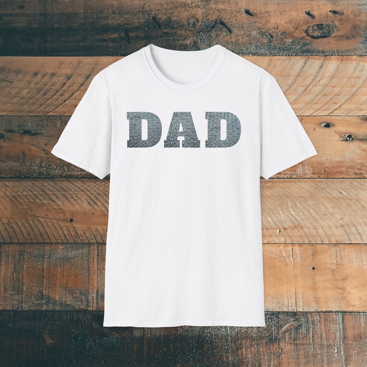 White t-shirt with 'DAD' containing silver diamond plate within text on a wooden background. Brilliantmischief.shop