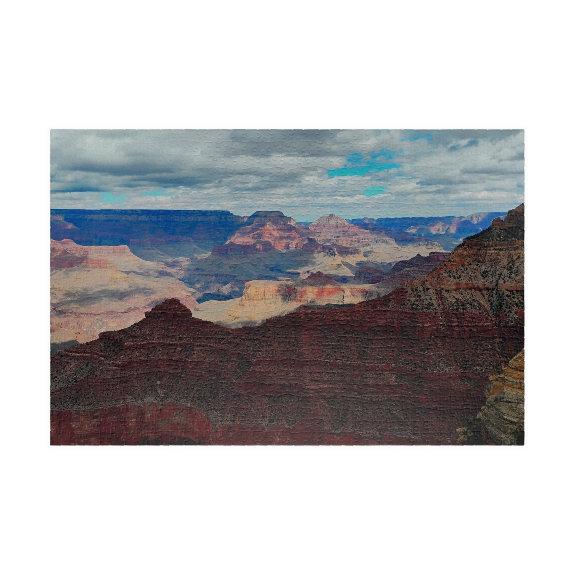Scenic view of the Grand Canyon with layered rock formations and a cloudy sky.
