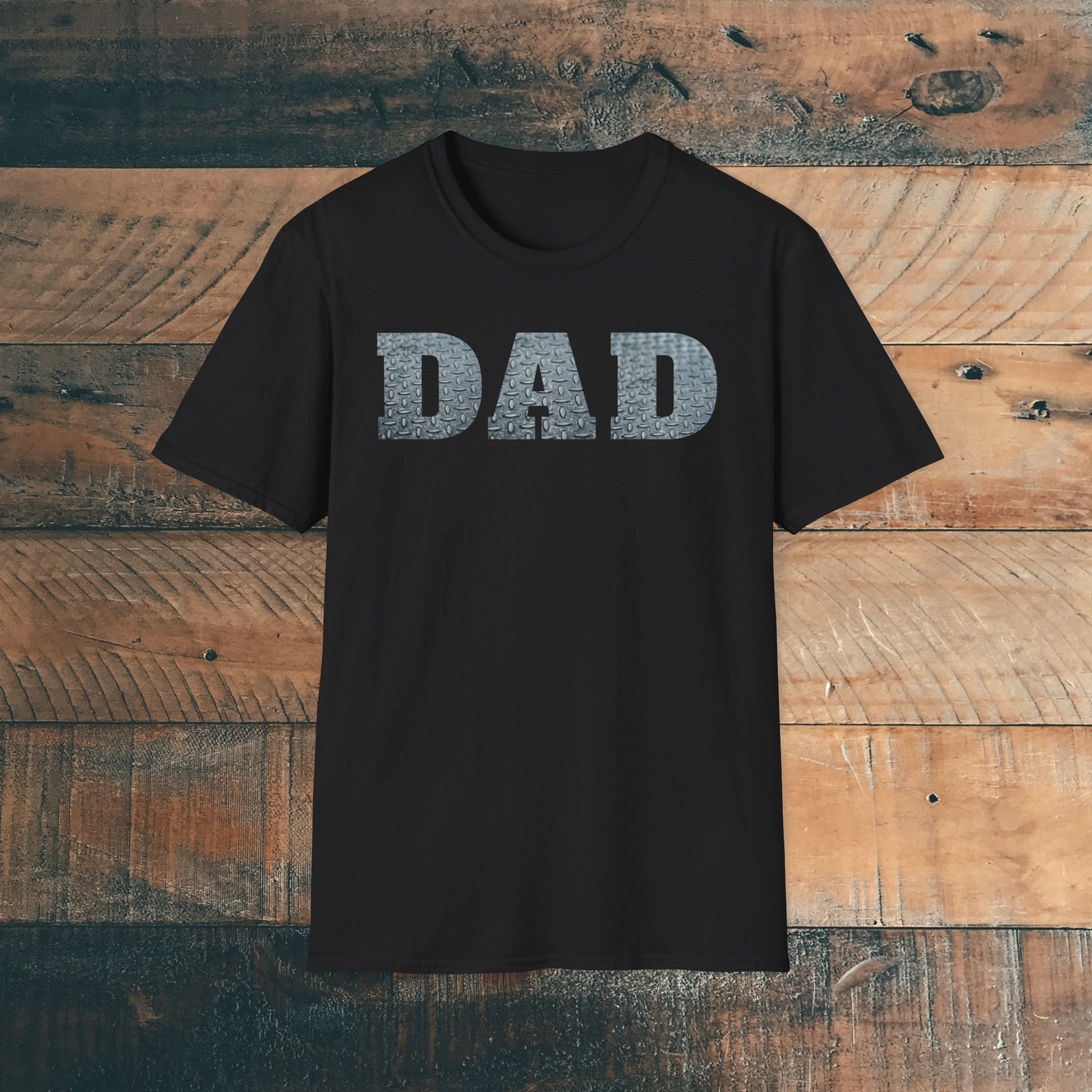 Black t-shirt with 'DAD' containing silver diamond plate within text on a wooden background. Brilliantmischief.shop
