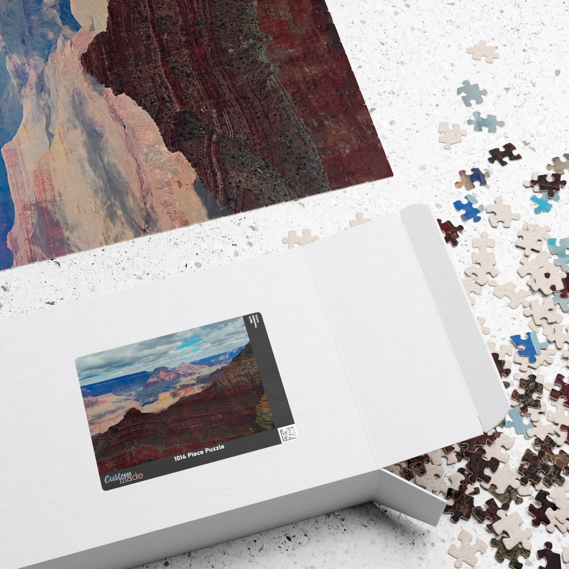 Jigsaw puzzle with completed pieces and a box featuring a scenic design.