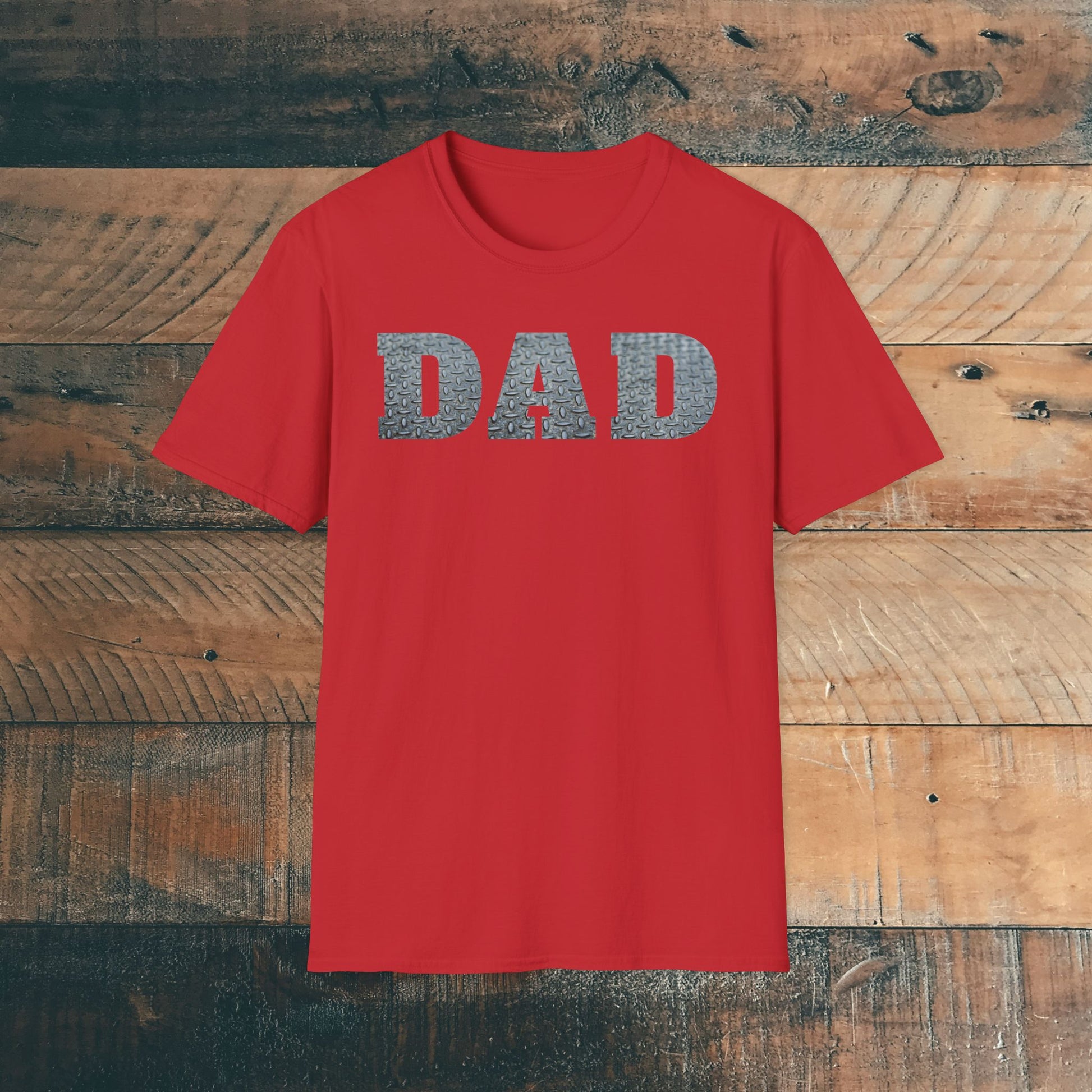 Red t-shirt with 'DAD' containing silver diamond plate within text on a wooden background. Brilliantmischief.shop